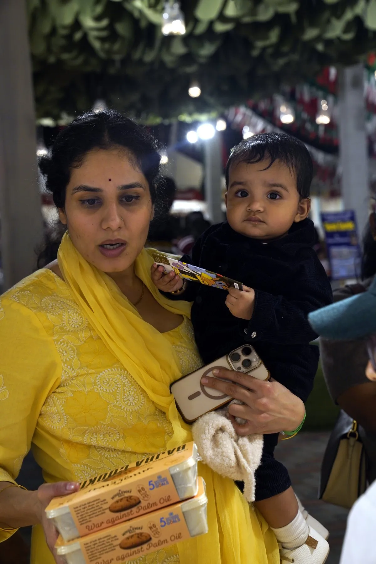 A mother with her baby holding a box of Wholeway Bajra Cookies