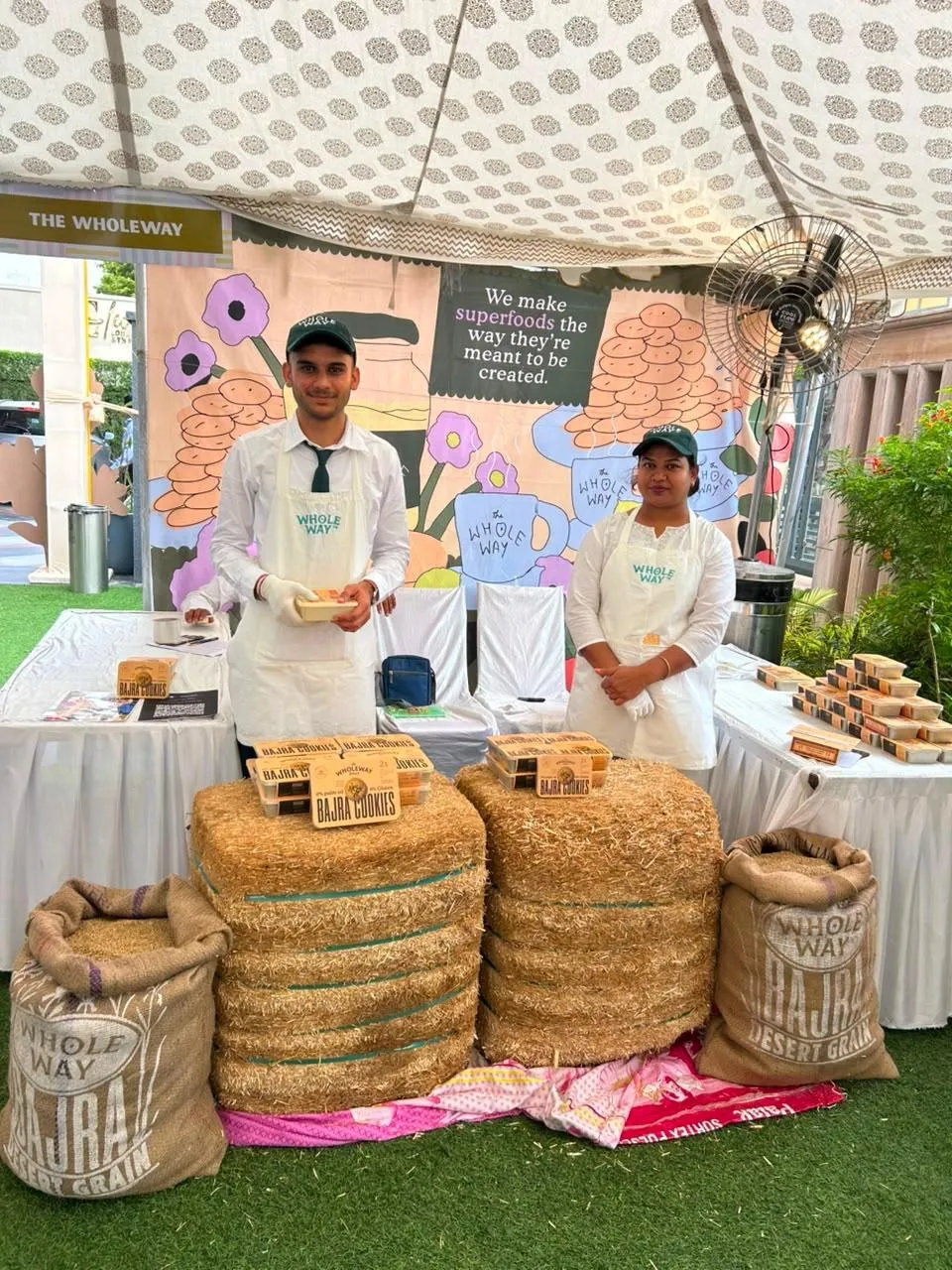 The Wholeway team at their stall with hay bales and cookie boxes